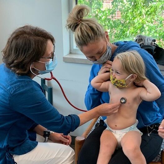 Pediatric provider Sasha Ormand checking a toddler patient's heart rate.